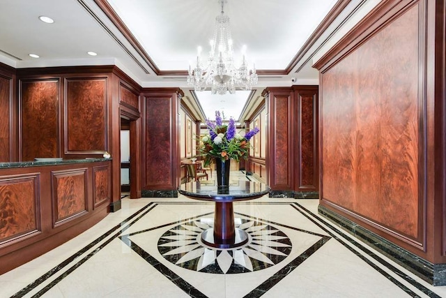 corridor with inlaid floor details, a chandelier, recessed lighting, and ornamental molding