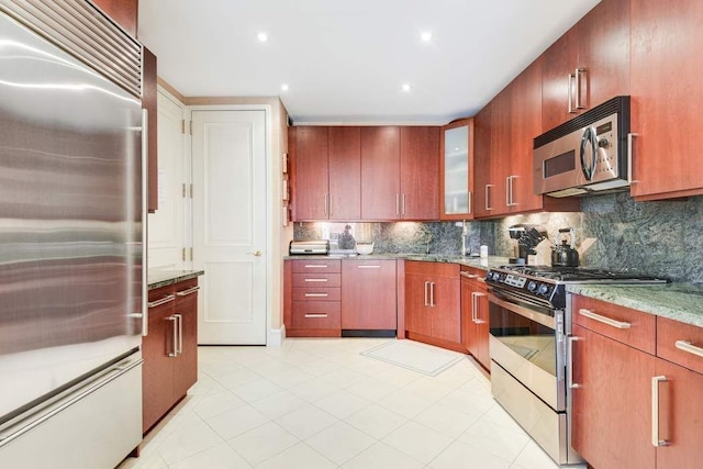 kitchen with appliances with stainless steel finishes, tasteful backsplash, light stone counters, and recessed lighting