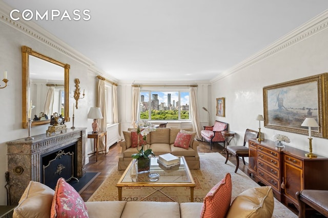 living room featuring a view of city, a fireplace with raised hearth, and crown molding