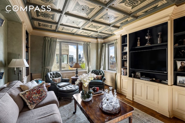 living area with built in features, coffered ceiling, crown molding, and wood finished floors