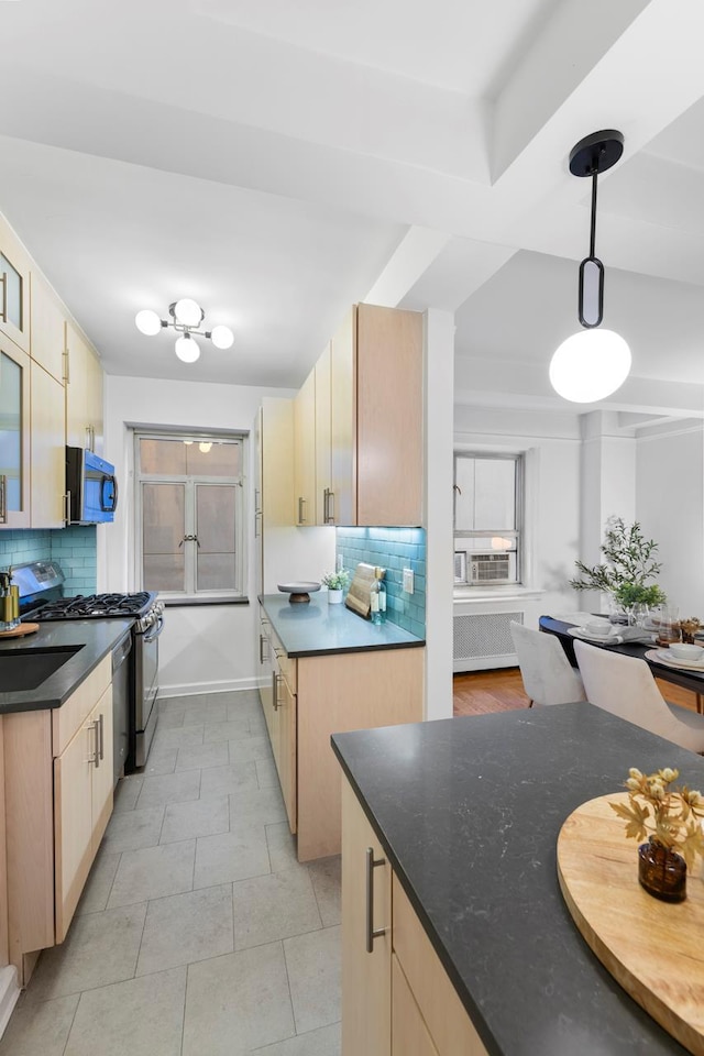 kitchen with stainless steel appliances, dark countertops, radiator, and tasteful backsplash
