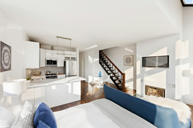 bedroom featuring sink, dark wood-type flooring, and stainless steel refrigerator