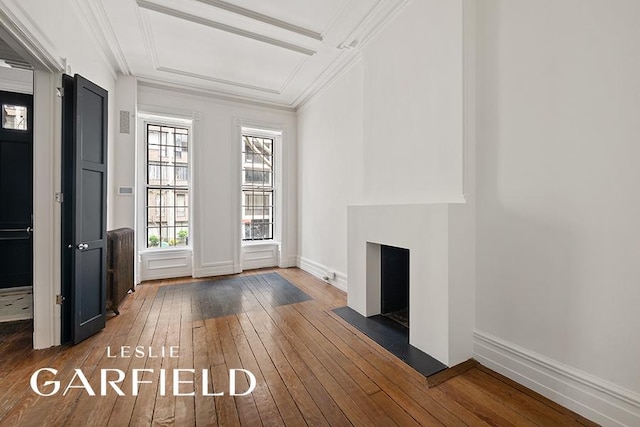 interior space featuring ornamental molding, baseboards, and hardwood / wood-style flooring