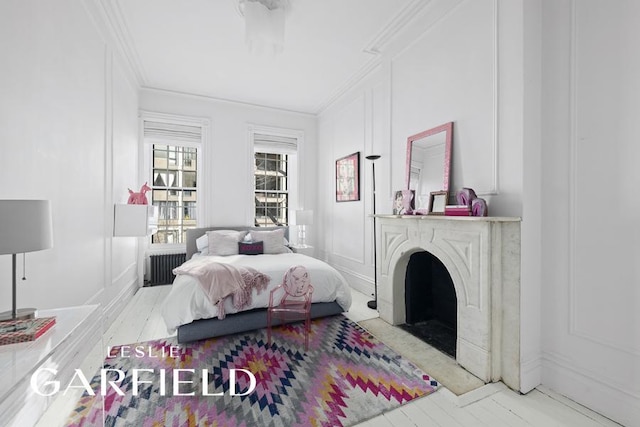 bedroom with crown molding, a decorative wall, and radiator heating unit