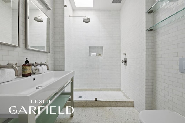 bathroom featuring a stall shower, tile walls, toilet, and vanity