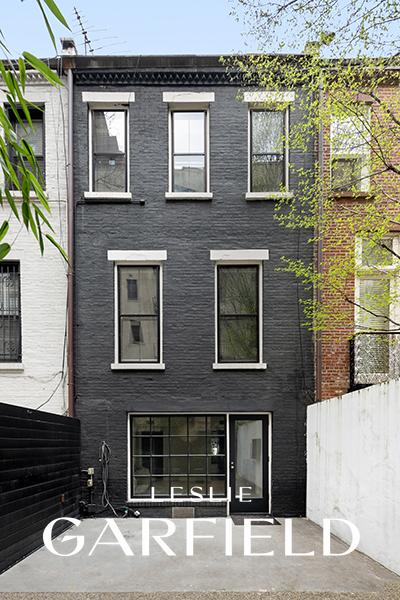 back of house featuring brick siding and fence