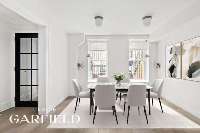 dining space featuring baseboards and wood finished floors