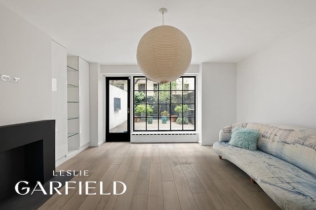 interior space with wood finished floors and baseboard heating