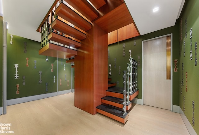 stairway featuring wood finished floors and baseboards