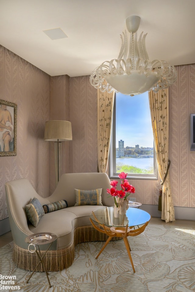 sitting room featuring wallpapered walls and a notable chandelier