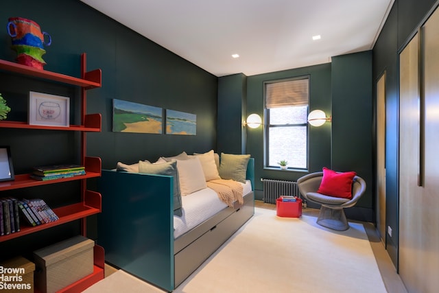 bedroom featuring radiator and light carpet