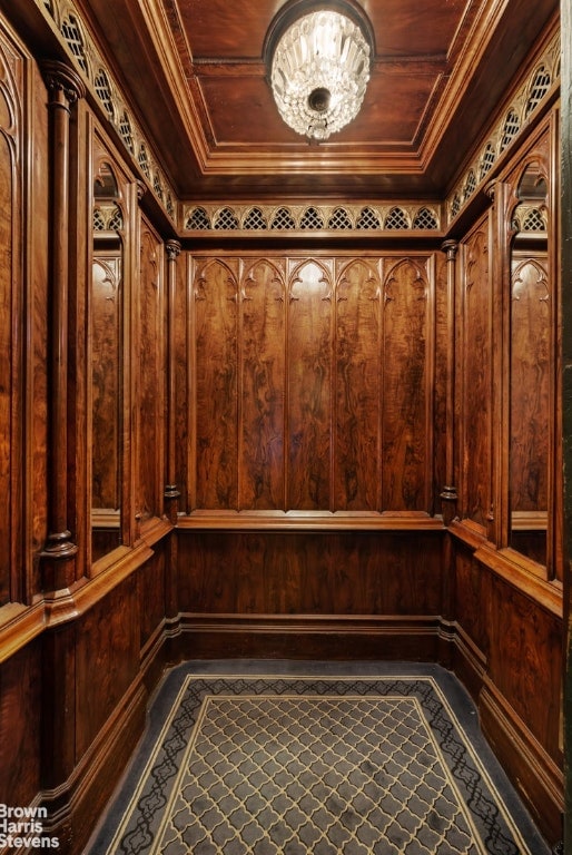 wine room featuring crown molding, wooden walls, ornate columns, and a sauna