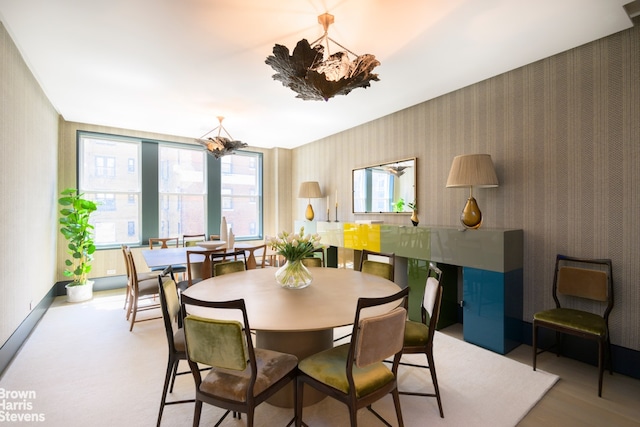 dining room featuring a notable chandelier, baseboards, and wallpapered walls