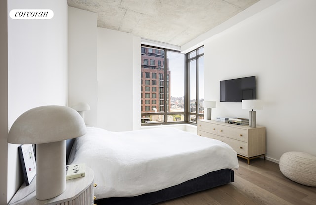 bedroom with baseboards and wood finished floors