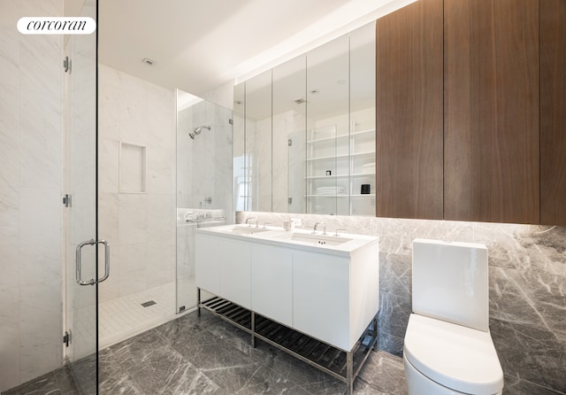 bathroom with marble finish floor, a sink, and a shower stall