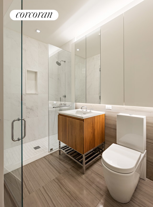 bathroom featuring a stall shower, vanity, and toilet