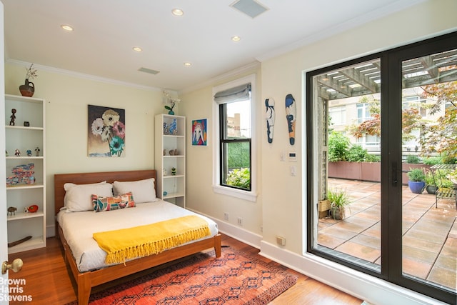 bedroom with access to exterior, visible vents, baseboards, ornamental molding, and wood finished floors