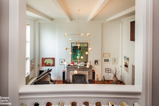 room details featuring beam ceiling, a chandelier, and a fireplace