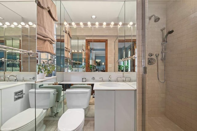 bathroom with a shower with door, vanity, and toilet