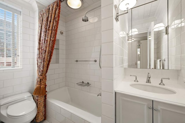 full bathroom featuring toilet, tile walls, ornamental molding, vanity, and shower / bath combo