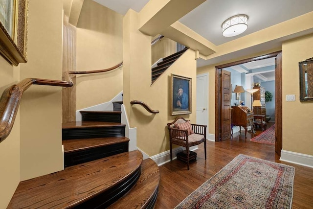 staircase with baseboards and wood finished floors