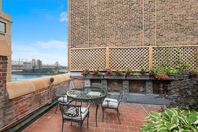 view of patio with a water view and exterior kitchen