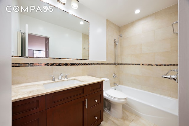 bathroom with tile patterned flooring, tile walls, toilet, shower / tub combination, and vanity