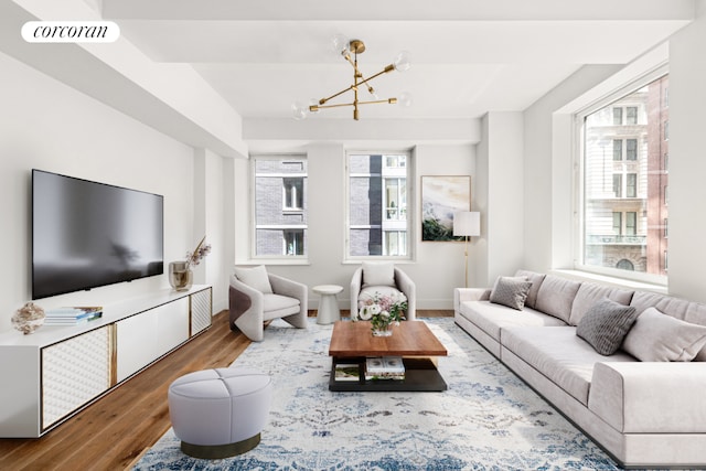 living room with hardwood / wood-style floors, plenty of natural light, and a chandelier