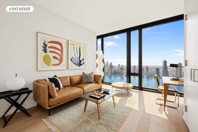 living room featuring a view of city, expansive windows, wood finished floors, and visible vents