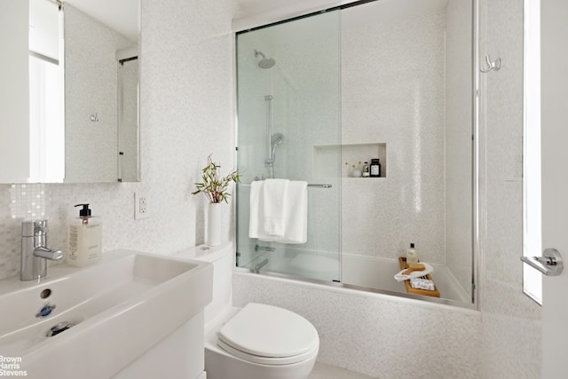 full bathroom with toilet, bath / shower combo with glass door, decorative backsplash, and sink