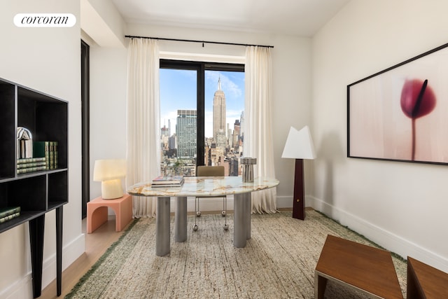 office space featuring baseboards, visible vents, and a city view