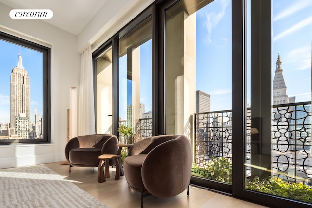 interior space with a view of city, visible vents, baseboards, and wood finished floors