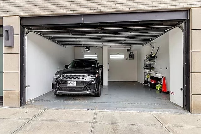 garage with driveway and a garage door opener