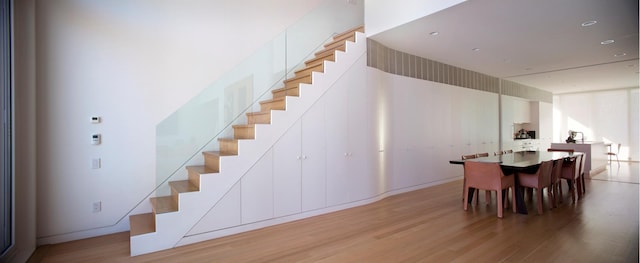 dining area featuring light wood finished floors and stairway