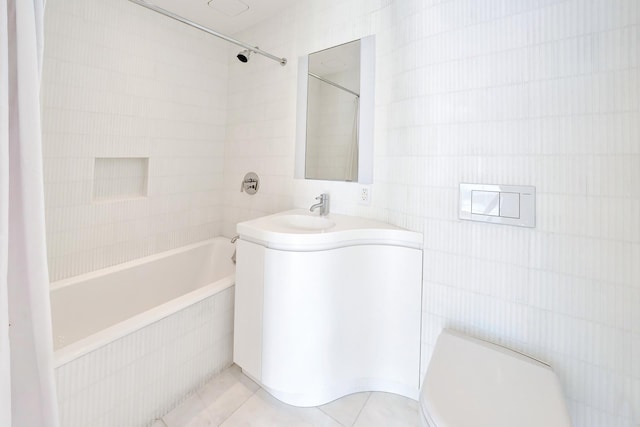 bathroom with bathing tub / shower combination, vanity, tile walls, and tile patterned floors