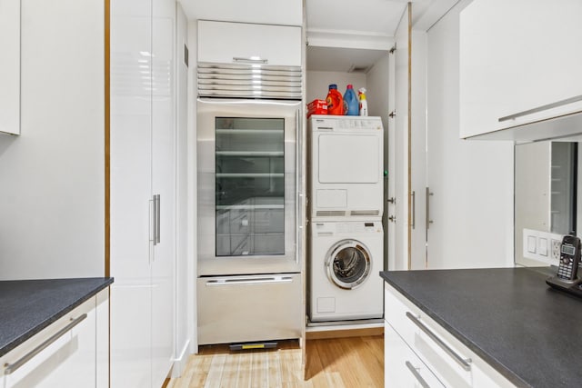 641 5th Ave Unit 27C, New York City, NY 10022 - washroom with stacked washer / drying machine and light wood-style flooring