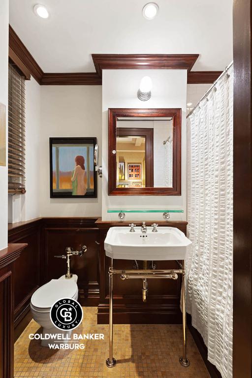 bathroom featuring toilet and ornamental molding