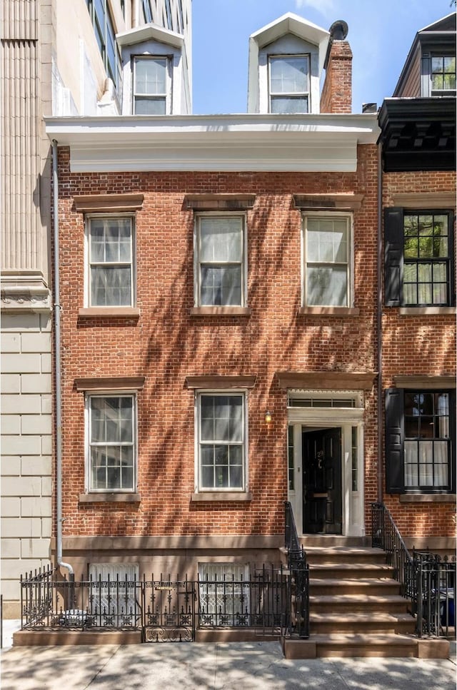 view of property with a fenced front yard and brick siding