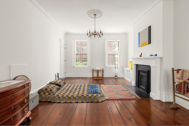 living area with ornamental molding, baseboards, a notable chandelier, and hardwood / wood-style floors