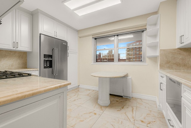 kitchen featuring appliances with stainless steel finishes, tile counters, decorative backsplash, and white cabinets