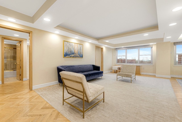 living area featuring baseboards, a raised ceiling, and recessed lighting