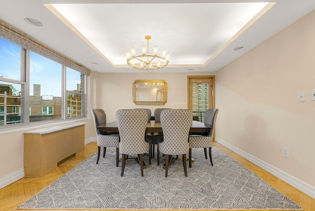 dining area featuring a tray ceiling and a chandelier