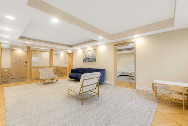 living room featuring a tray ceiling and light parquet flooring