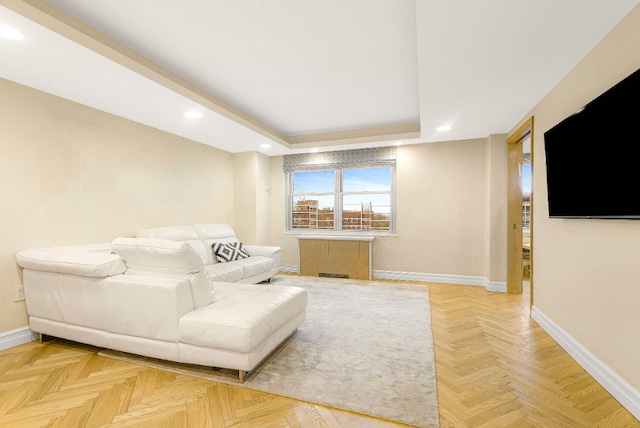 living room featuring parquet flooring and a raised ceiling