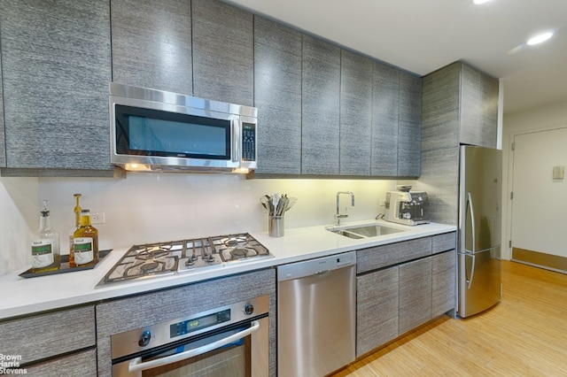 kitchen featuring appliances with stainless steel finishes, light hardwood / wood-style floors, and sink