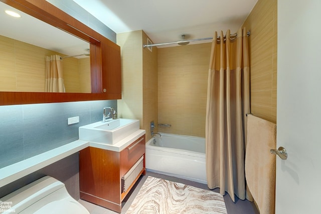 full bathroom with toilet, vanity, shower / bathtub combination with curtain, and tasteful backsplash