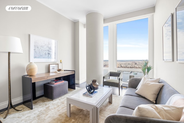 living area with baseboards, decorative columns, visible vents, and crown molding