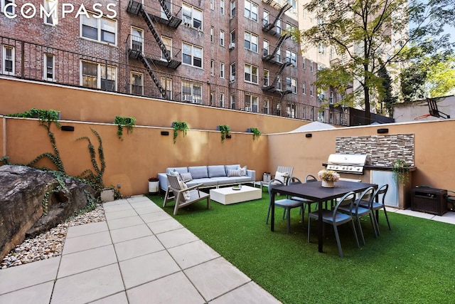 view of patio / terrace featuring an outdoor hangout area, a grill, and an outdoor kitchen