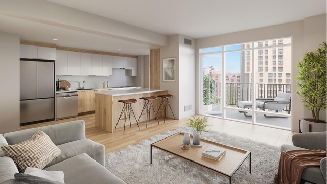 living room featuring sink and light hardwood / wood-style flooring