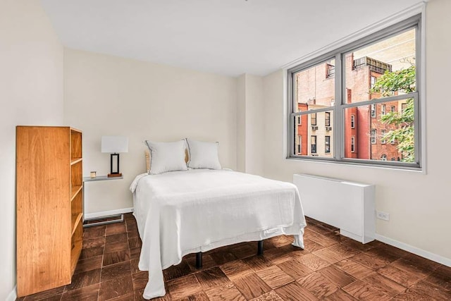 bedroom with radiator heating unit and baseboards